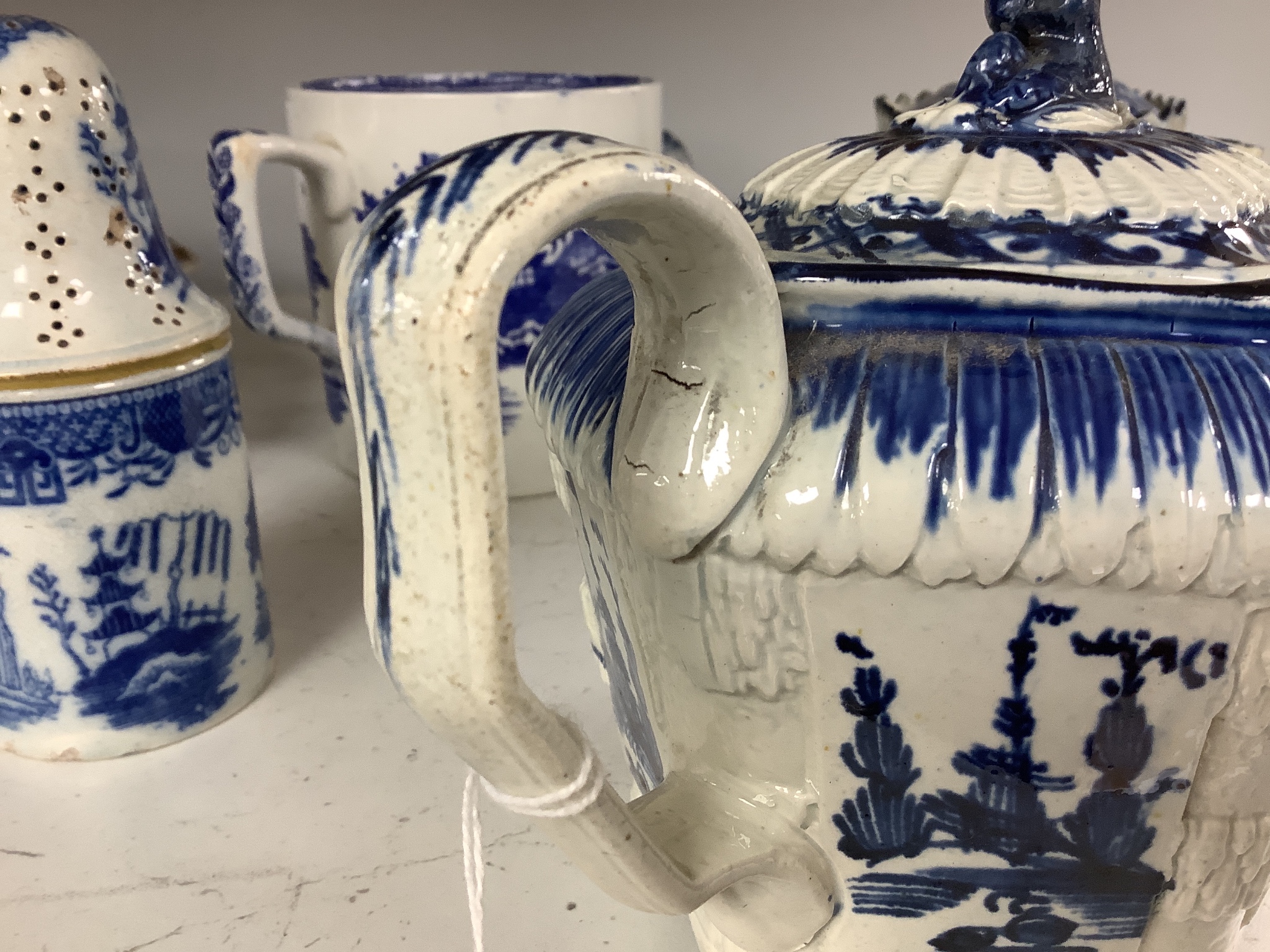 A collection of English blue and white pottery, various dates, comprising a moulded hexagonal teapot and cover, with widow finial, ovoid teapot and cover, lozenge section sugar bowl and cover, with swan finial, circular